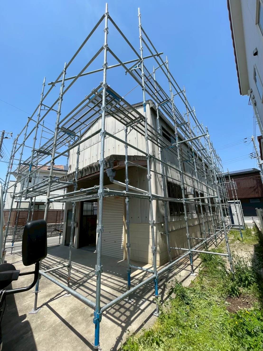 隣家に近い戸建て住宅へ組まれた外壁工事用の足場